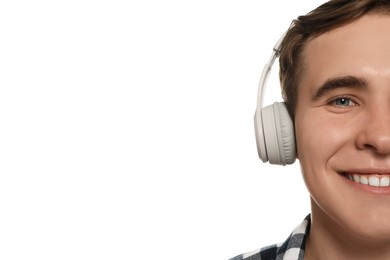 Handsome young man with headphones on white background, closeup