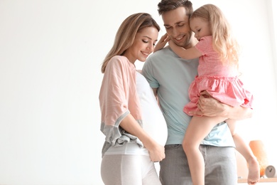 Photo of Young pregnant woman with her family at home