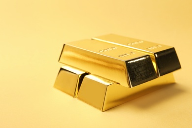 Photo of Precious shiny gold bars on color background