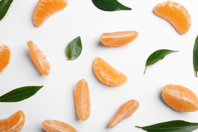 Photo of Composition with tangerine segments and leaves on white background, top view