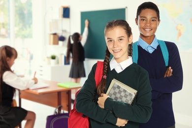 Image of Happy teens with backpacks in school classroom