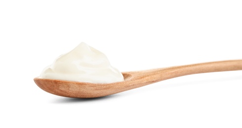 Photo of Wooden spoon with sour cream on white background