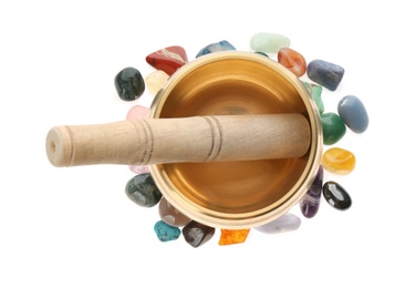 Photo of Golden singing bowl with mallet and healing stones on white background, top view