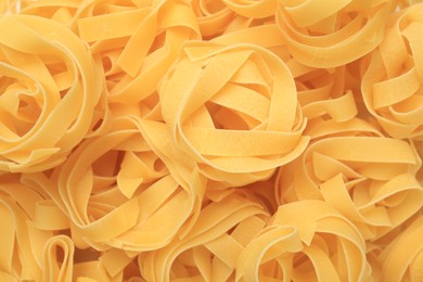 Photo of Raw tagliatelle pasta as background, top view