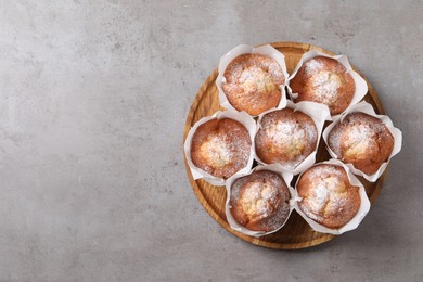 Photo of Delicious muffins on grey table, top view. space for text