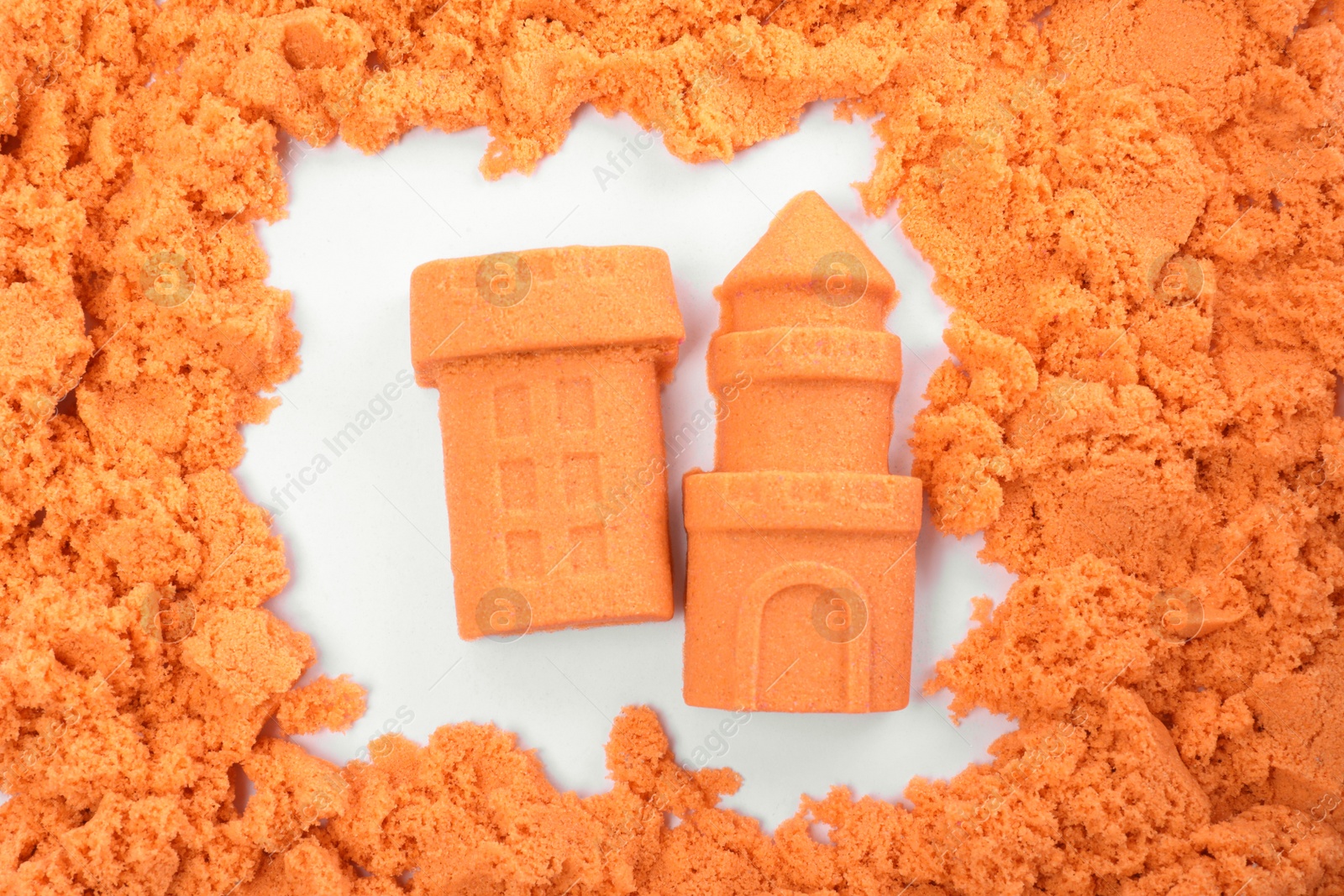 Photo of Castle and tower made of kinetic sand on white background, top view