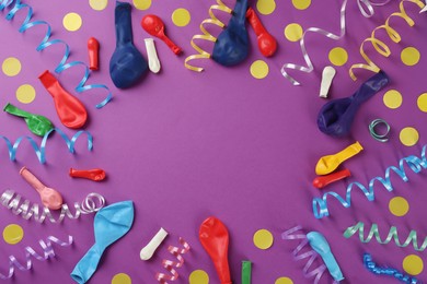 Photo of Frame of colorful serpentine streamers and other party accessories on purple background, flat lay. Space for text