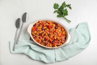 Photo of Baking dish with chili con carne on light background, top view