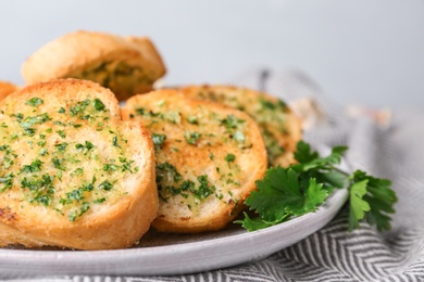 Photo of Slices of toasted bread with garlic and herbs on table, closeup