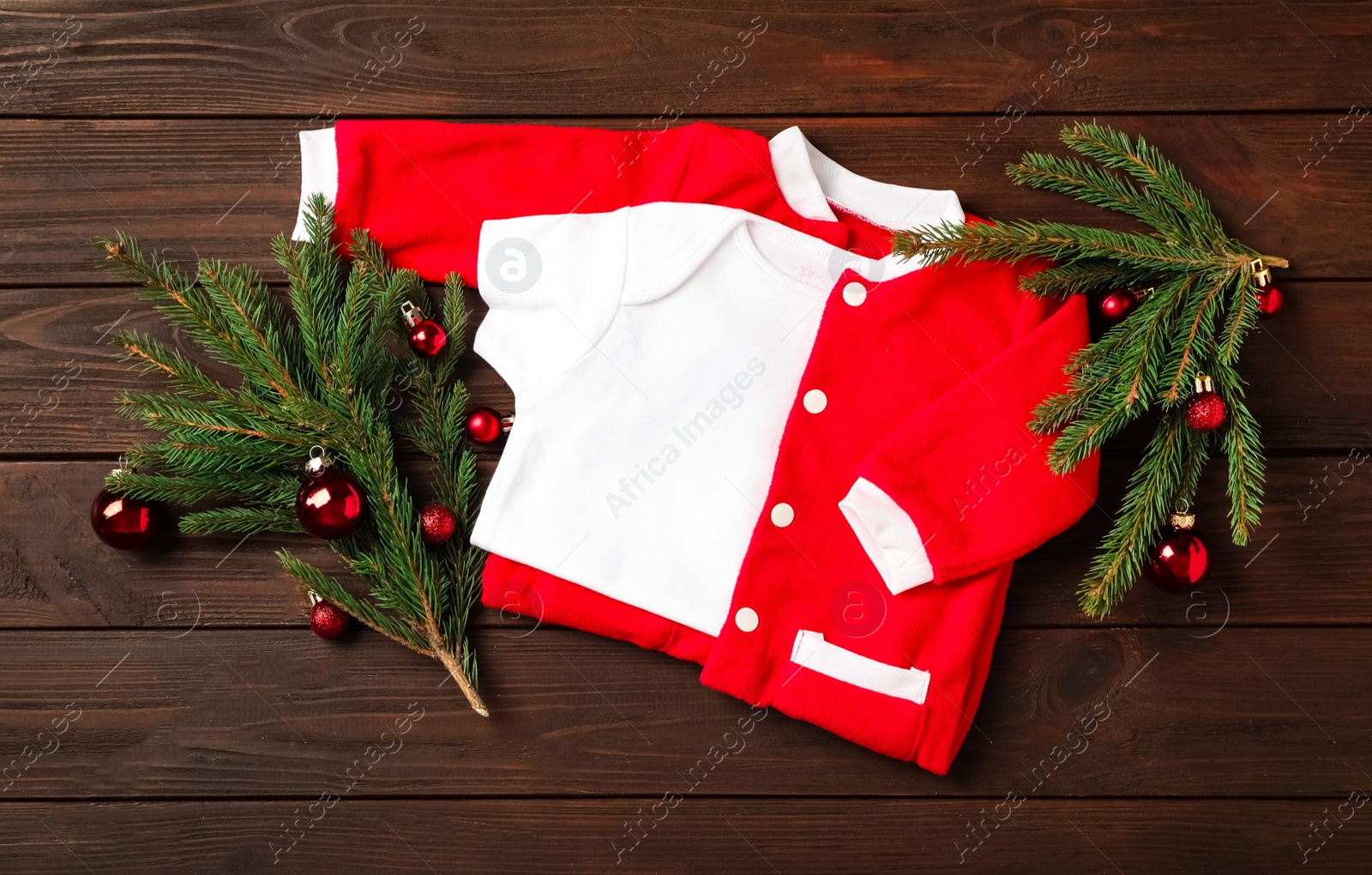 Photo of Flat lay composition with cute Christmas baby clothes on wooden background