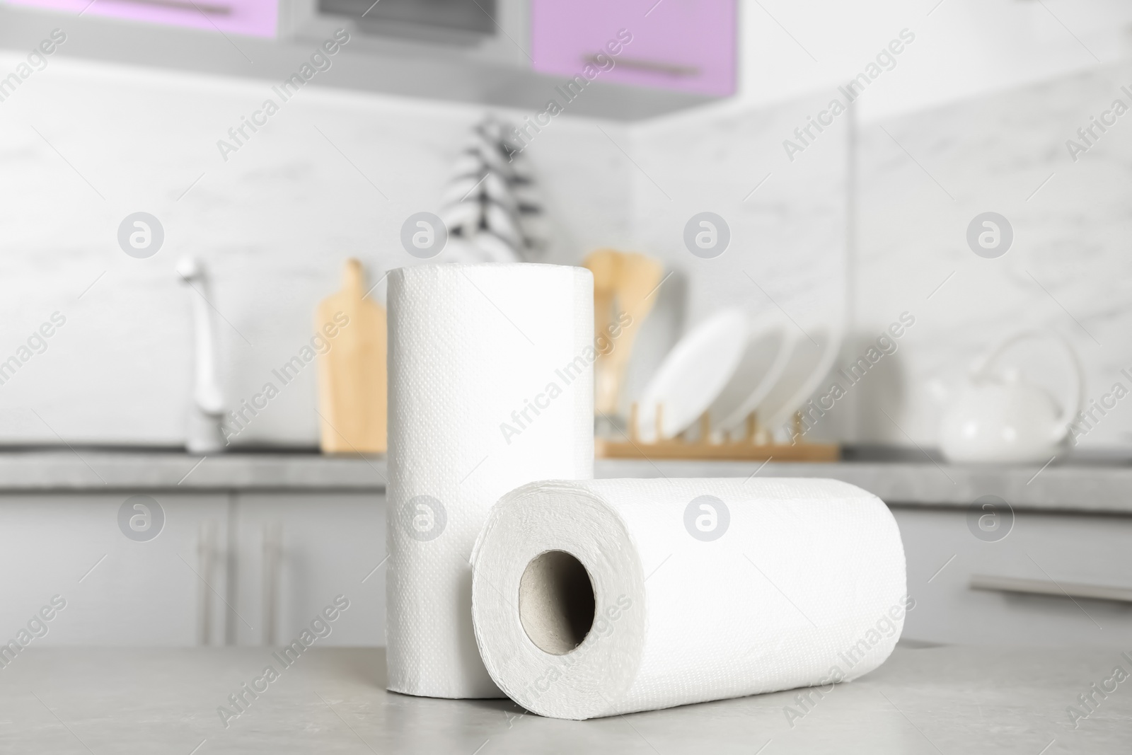 Photo of Rolls of paper towels on light grey table in kitchen