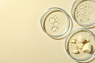 Photo of Many Petri dishes and cosmetic products on beige background, flat lay. Space for text