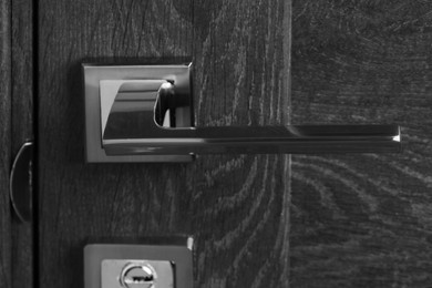 Photo of Closed wooden door with metal handle, closeup