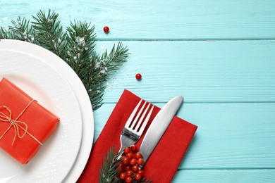 Photo of Christmas table setting on blue wooden background, top view. Space for text