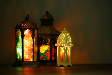 Photo of Decorative Arabic lanterns on table against dark background
