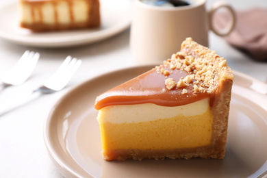 Photo of Piece of delicious cake with caramel served on light table
