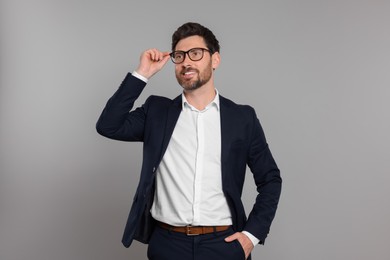 Photo of Happy real estate agent in glasses on grey background