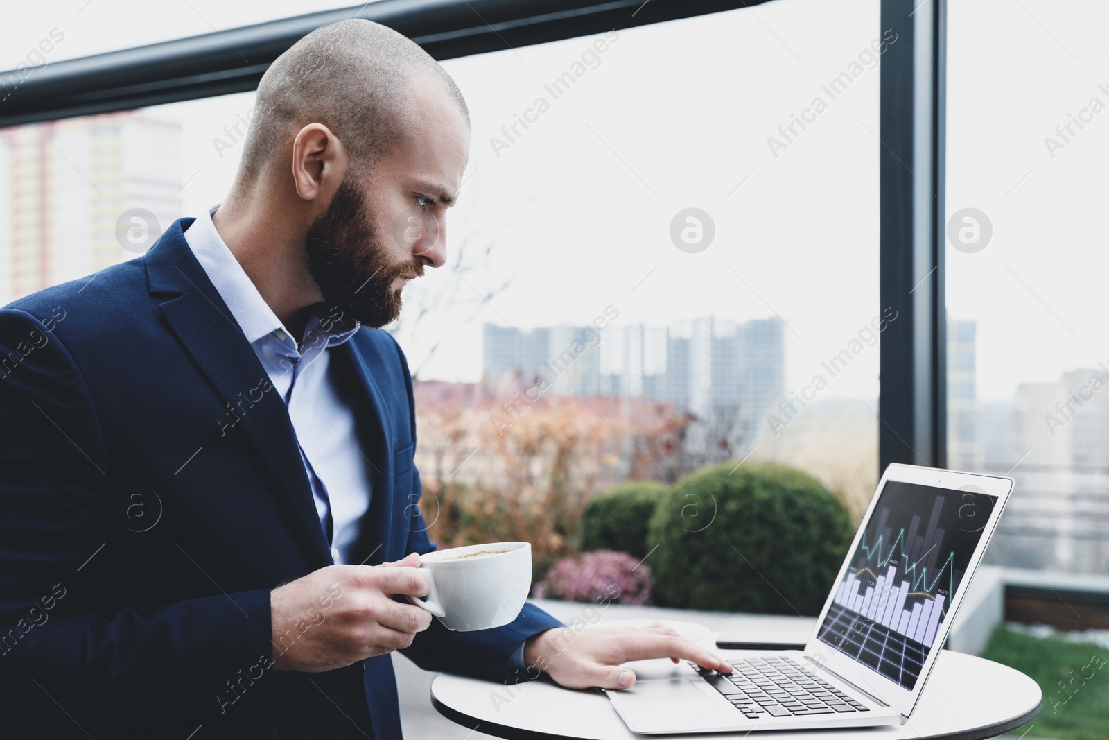 Image of Broker with laptop and coffee in office. Forex trading