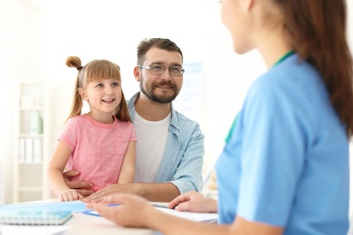 Photo of Little girl with father visiting children's doctor in hospital