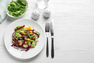 Photo of Plate with delicious beet salad on wooden table, top view