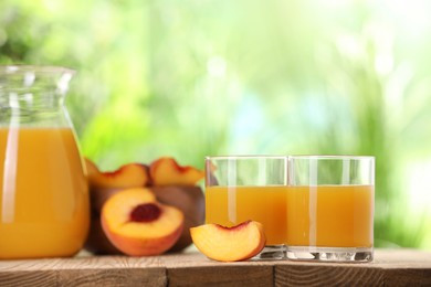 Photo of Tasty peach juice and fresh fruits on wooden table outdoors, space for text