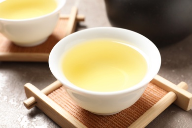 Cup of Tie Guan Yin oolong tea on table, closeup
