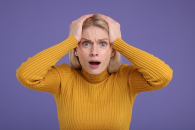 Photo of Portrait of surprised woman on violet background