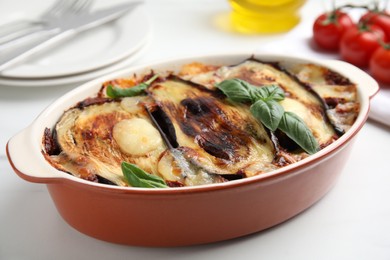 Photo of Delicious eggplant lasagna in baking dish on white table, closeup