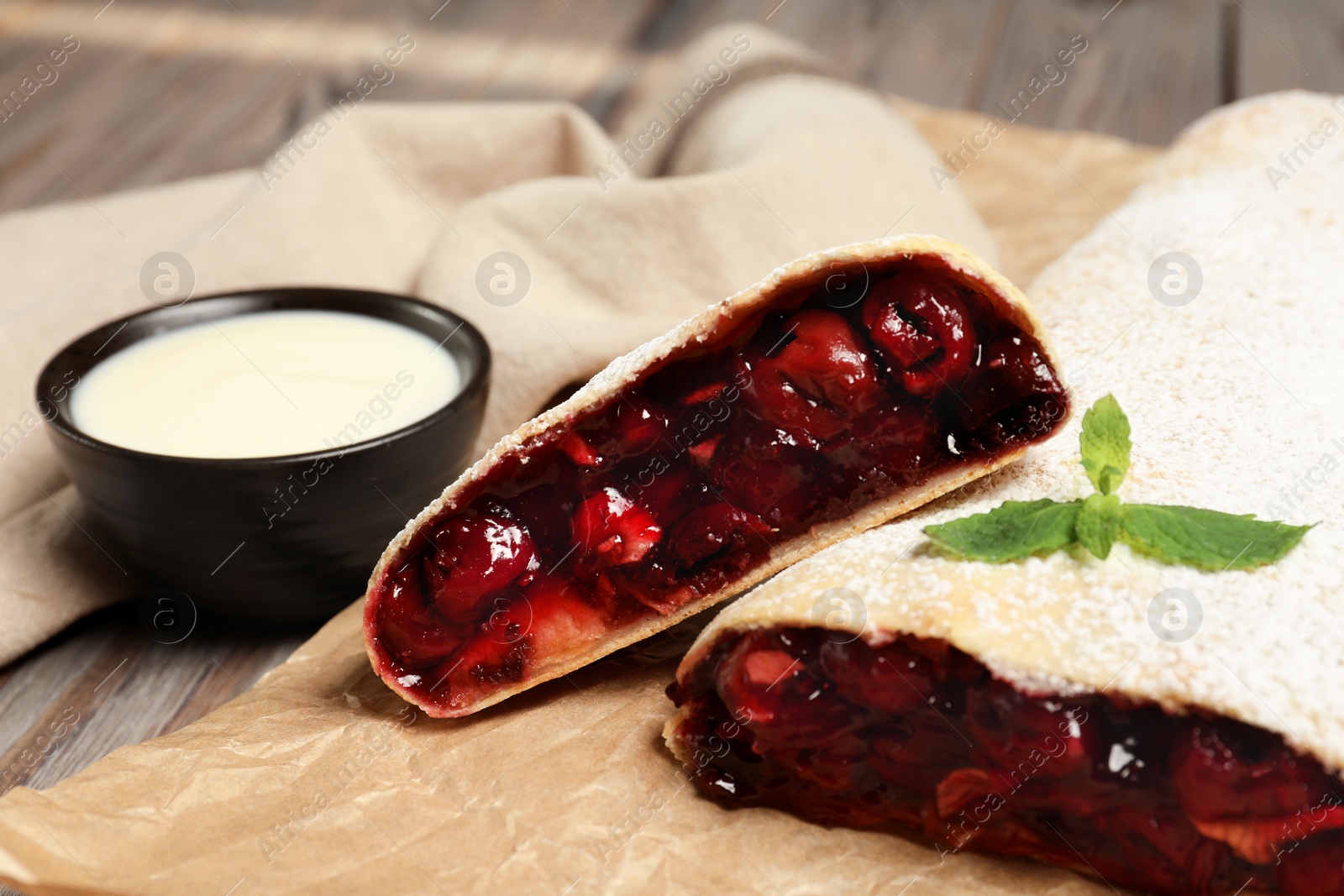 Delicious strudel with cherries served on wooden table, closeup Photo of Delicious strudel with cherries served on wooden table, closeup