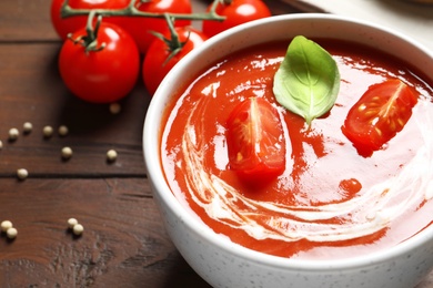 Photo of Bowl with fresh homemade tomato soup on table, closeup. Space for text