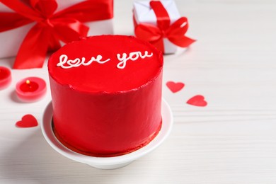Photo of Bento cake with text Love You, gift boxes, candles and paper hearts on white wooden table, space for text. St. Valentine's day surprise