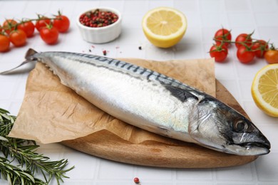 Photo of Raw mackerel and rosemary on white table