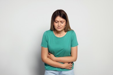 Photo of Young woman suffering from menstrual pain on grey background