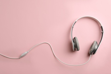 Photo of Stylish headphones on color background, top view. Space for text
