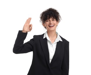 Photo of Beautiful happy businesswoman in suit showing OK gesture on white background