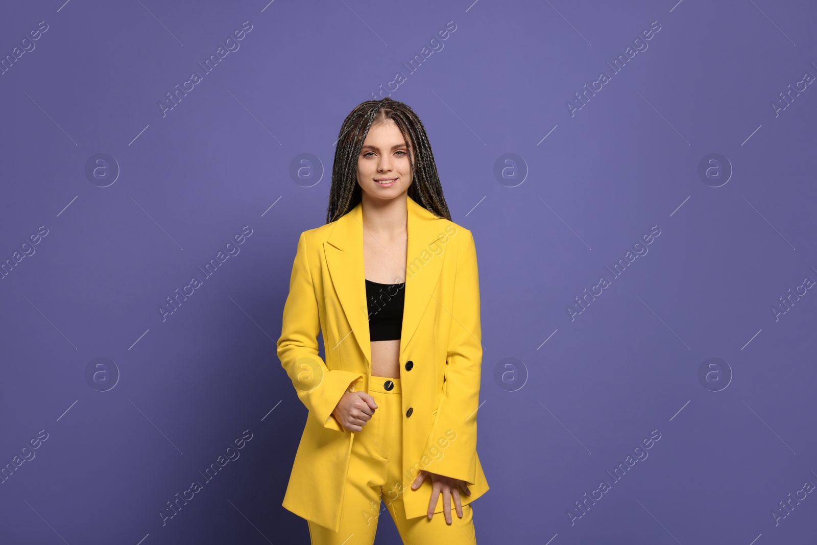 Photo of Beautiful woman with long african braids on purple background