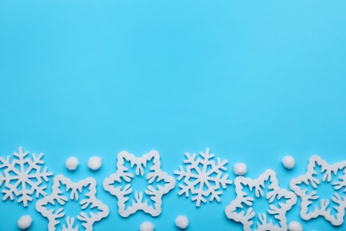 Photo of Beautiful decorative snowflakes on light blue background, flat lay. Space for text