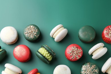 Photo of Beautifully decorated Christmas macarons on green background, flat lay