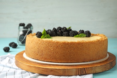 Photo of Delicious cheesecake decorated with blackberries on table