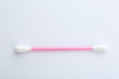 Photo of Pink plastic cotton swab on white background