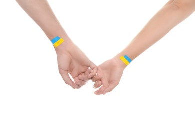 Photo of Man and woman with painted Ukrainian flags on their hands against white background, closeup
