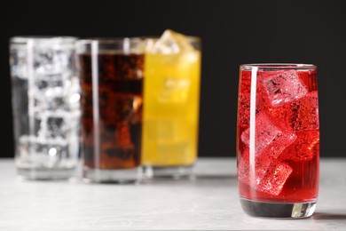 Photo of Glass of refreshing soda water with ice cubes on white table. Space for text