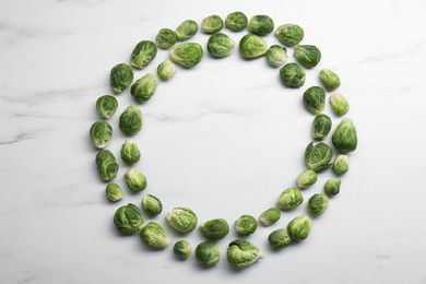 Photo of Frame of Brussels sprouts on white marble table, flat lay. Space for text
