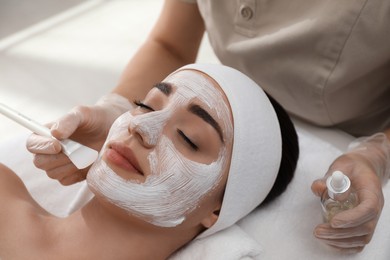 Photo of Young woman during face peeling procedure in salon