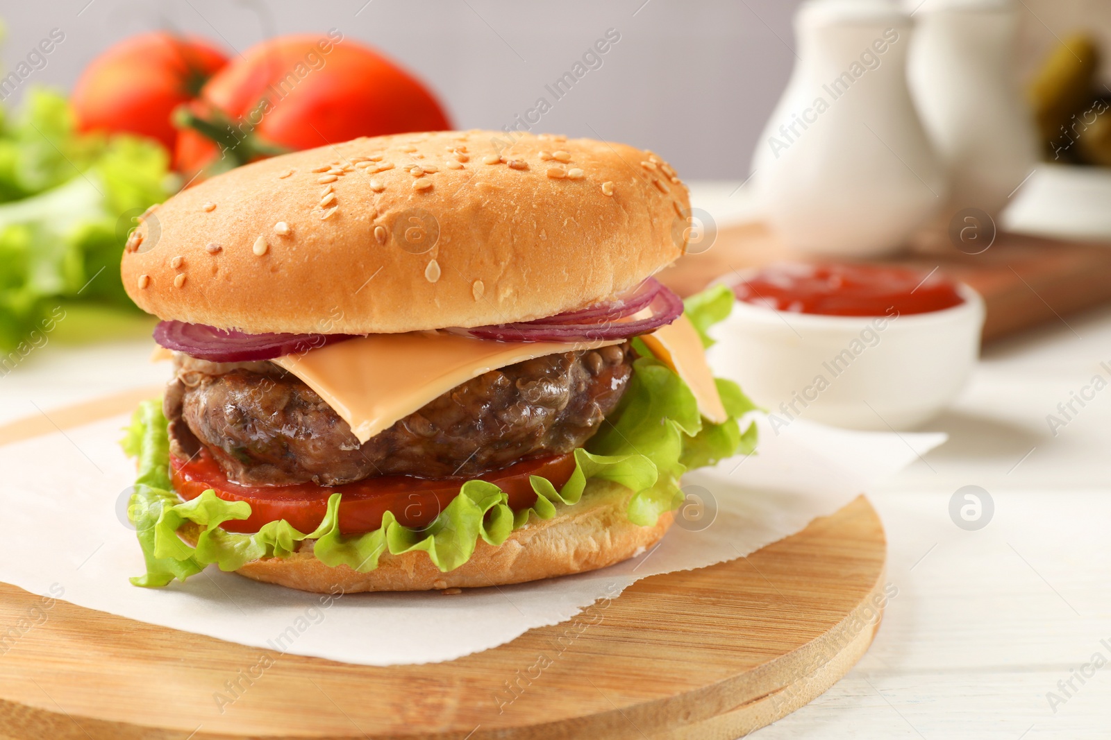 Photo of Tasty hamburger with patty, cheese and vegetables served on table, closeup