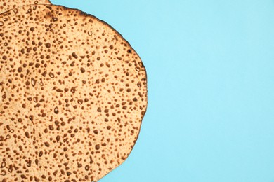 Photo of Tasty matzo on light blue background, top view with space for text. Passover (Pesach) celebration