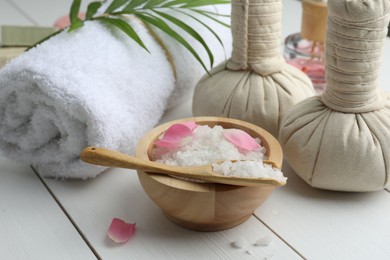 Photo of Spa composition. Towel, herbal bags and sea salt on white wooden table