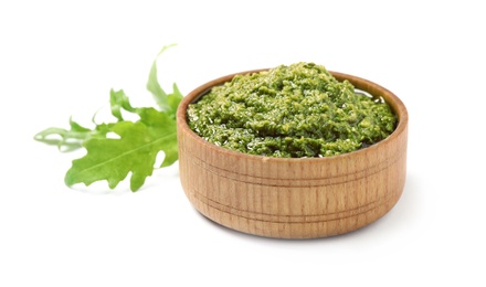 Photo of Bowl of tasty pesto and arugula on white background