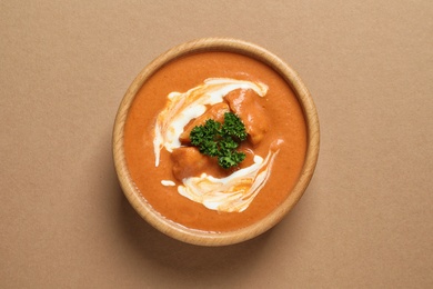 Bowl of delicious butter chicken on color background, top view. Traditional indian Murgh Makhani