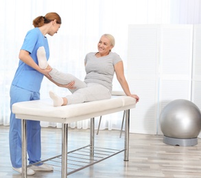 Photo of Physiotherapist working with patient in clinic, space for text. Rehabilitation therapy